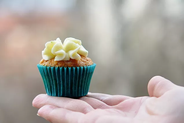 En cupcake som ligger i en öppen hand. Foto. Bild av GLady från Pixabay.
