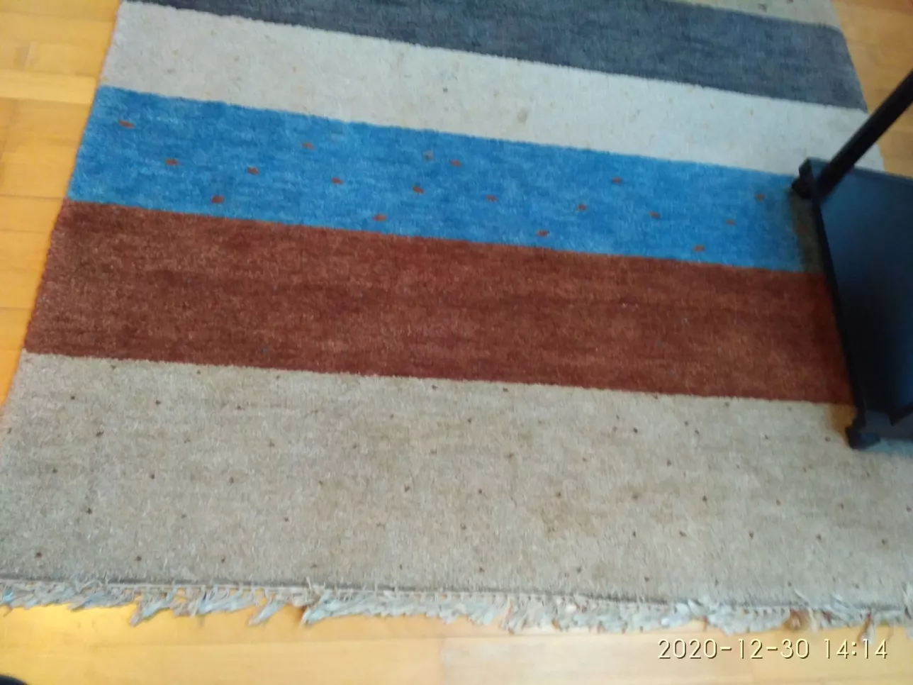 A slightly dirty rug with multicoloured bands. Photo: Tenant