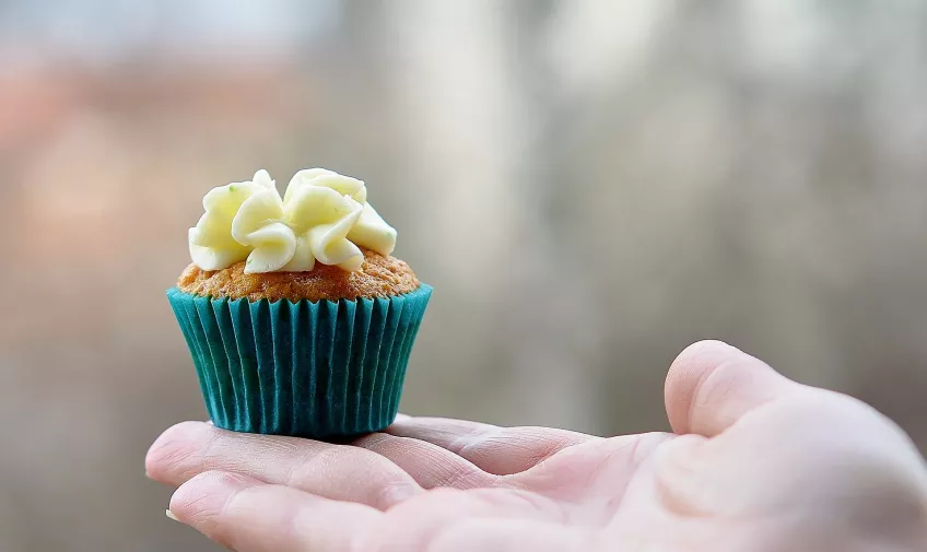 En cupcake som ligger i en öppen hand. Foto. Bild av GLady från Pixabay.